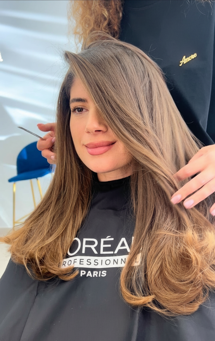 Balayage caramel froid réalisé par A More Beauty Salon à Cannes, technique L’Oréal Professionnel avec patine Dia Light et finition wavy, dans un salon de coiffure premium.
